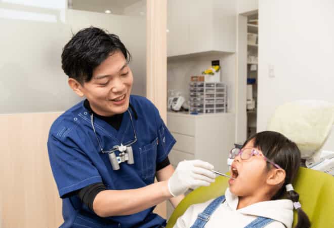 定期検診に来た子どもと診察している歯科医師